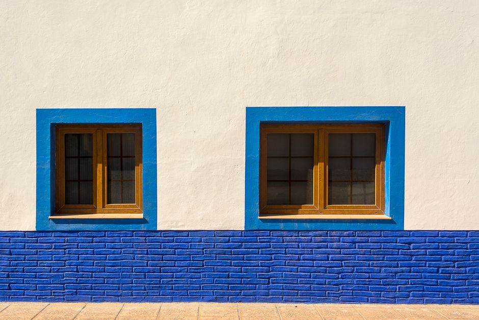 Blue painted window frames on a white wall.