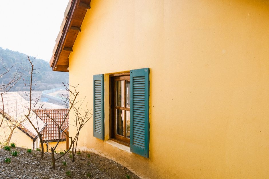Yellow house with blue painted shutters.