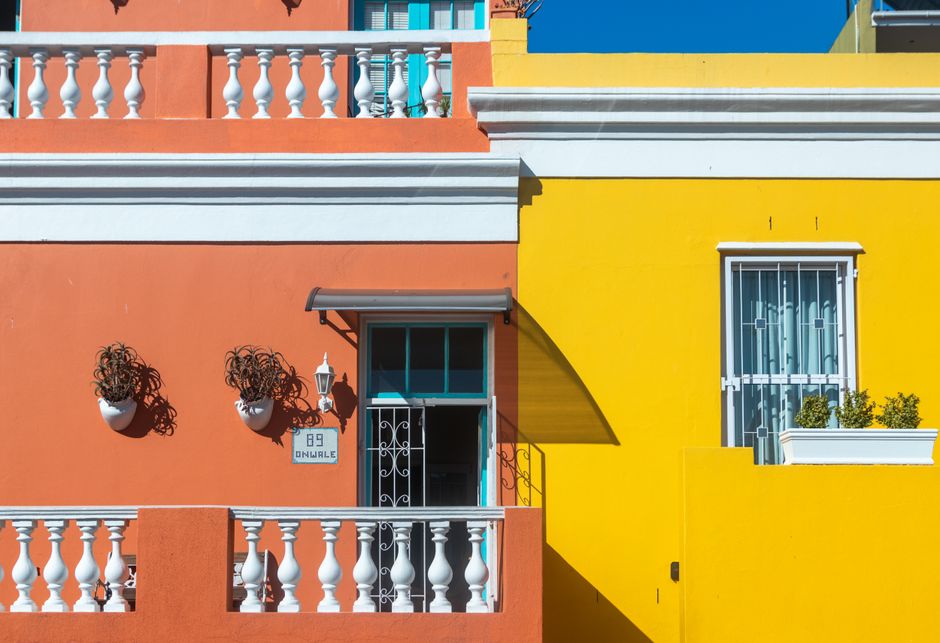 Row of freshly painted house fronts in warm colors.